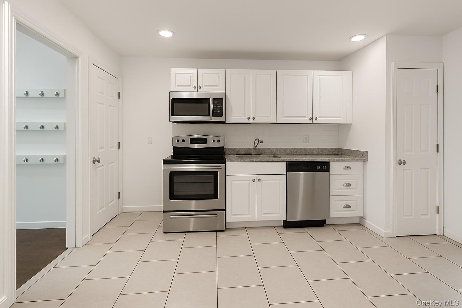 1243 Pea Pond Road North Bellmore, NY 11710 - Photo 7 of 16 a kitchen with white cabinets and white appliances