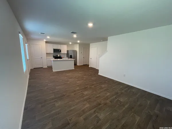 a view of a kitchen with a sink and dishwasher a refrigerator with wooden floor