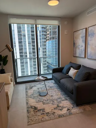 a living room with furniture and a floor to ceiling window