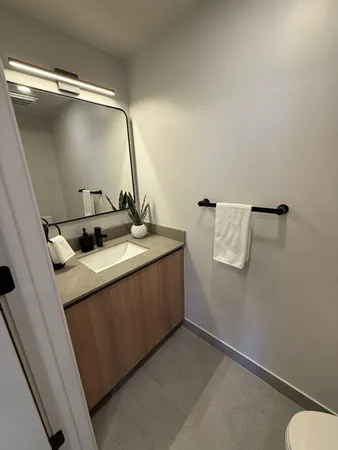 a bathroom with a sink and mirror with toilet
