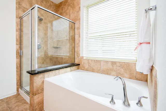 a white bath tub sitting next to a shower