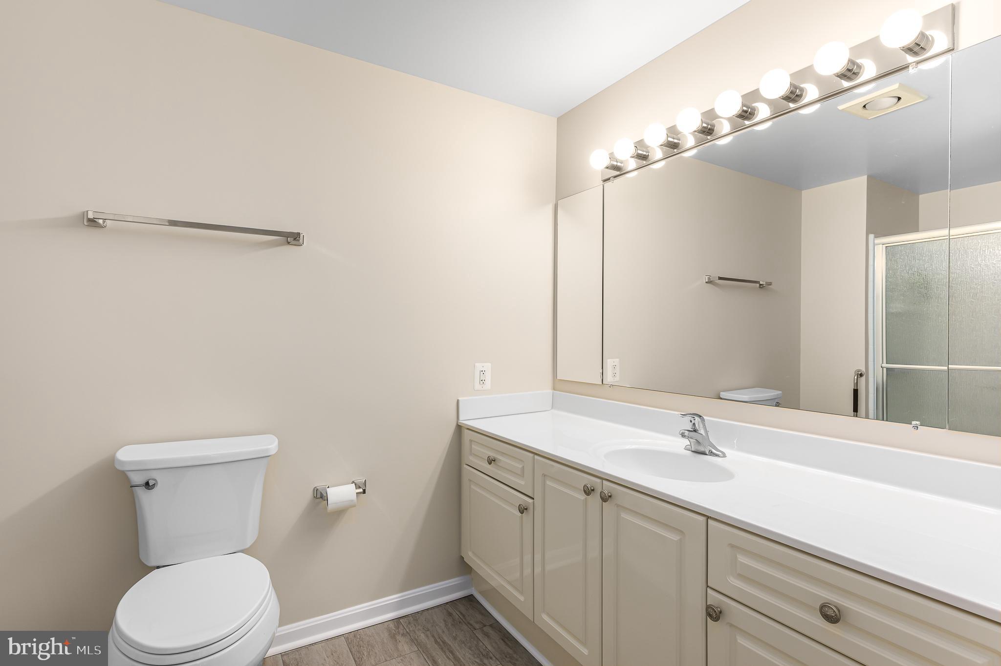 19355 Cypress Ridge Terrace, Unit 404 Leesburg, VA 20176 - Photo 17 of 39 a bathroom with a double vanity sink toilet and a mirror