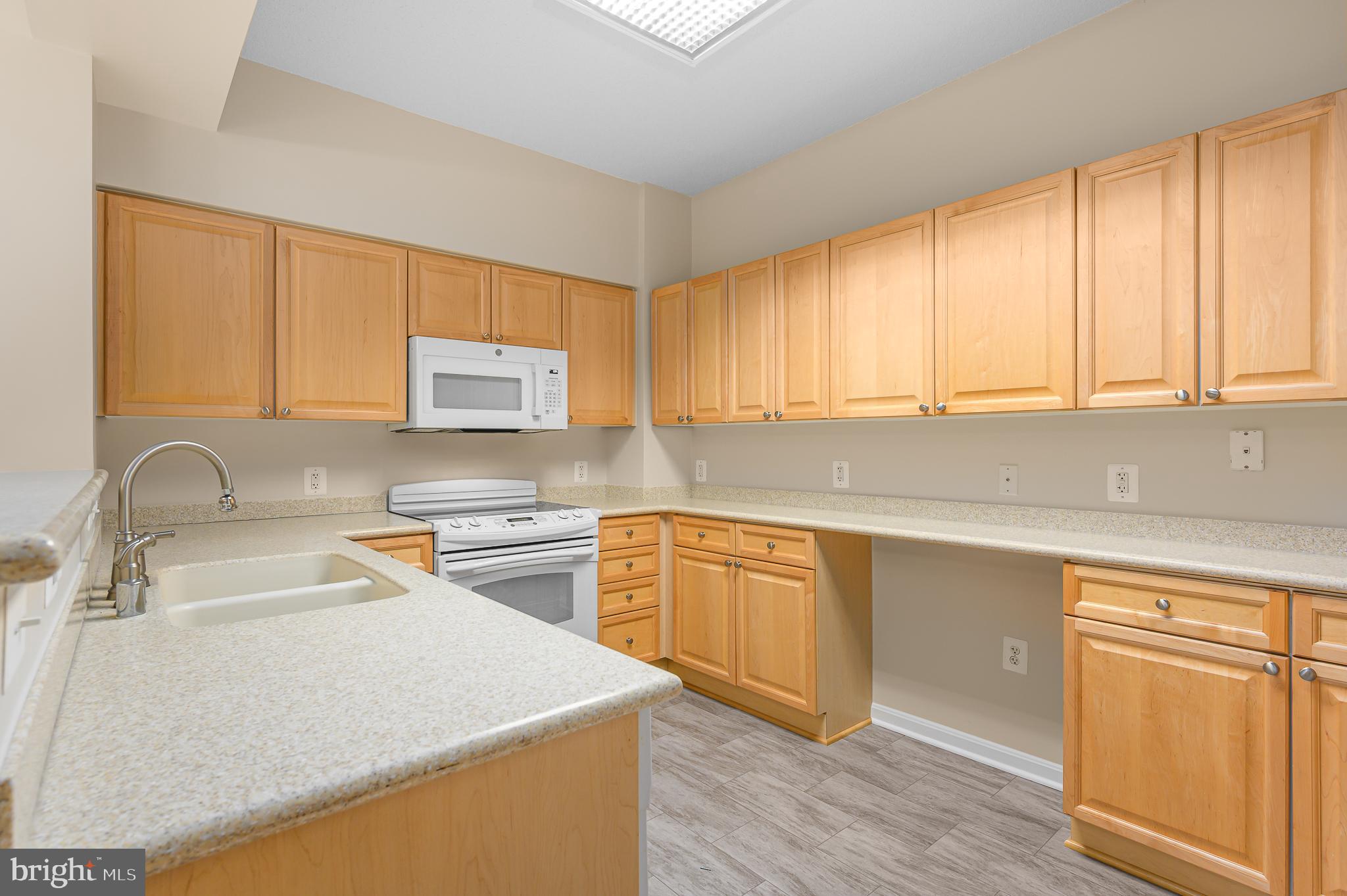 19355 Cypress Ridge Terrace, Unit 404 Leesburg, VA 20176 - Photo 9 of 39 a kitchen with stainless steel appliances granite countertop a sink a stove and a microwave