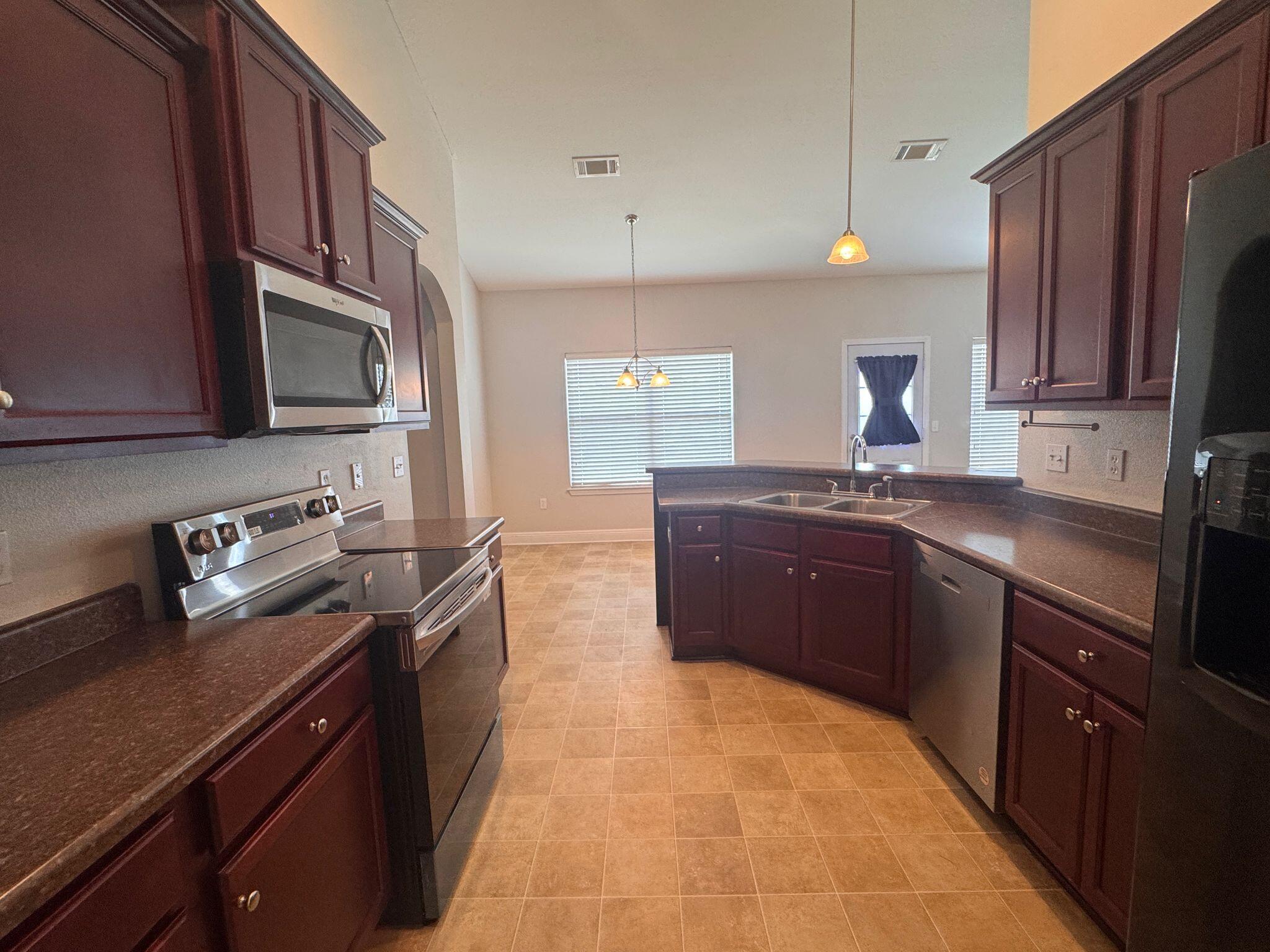 744 Lime Lane Crestview, FL 32536 - Photo 10 of 25 a kitchen with granite countertop stainless steel appliances and wooden cabinets