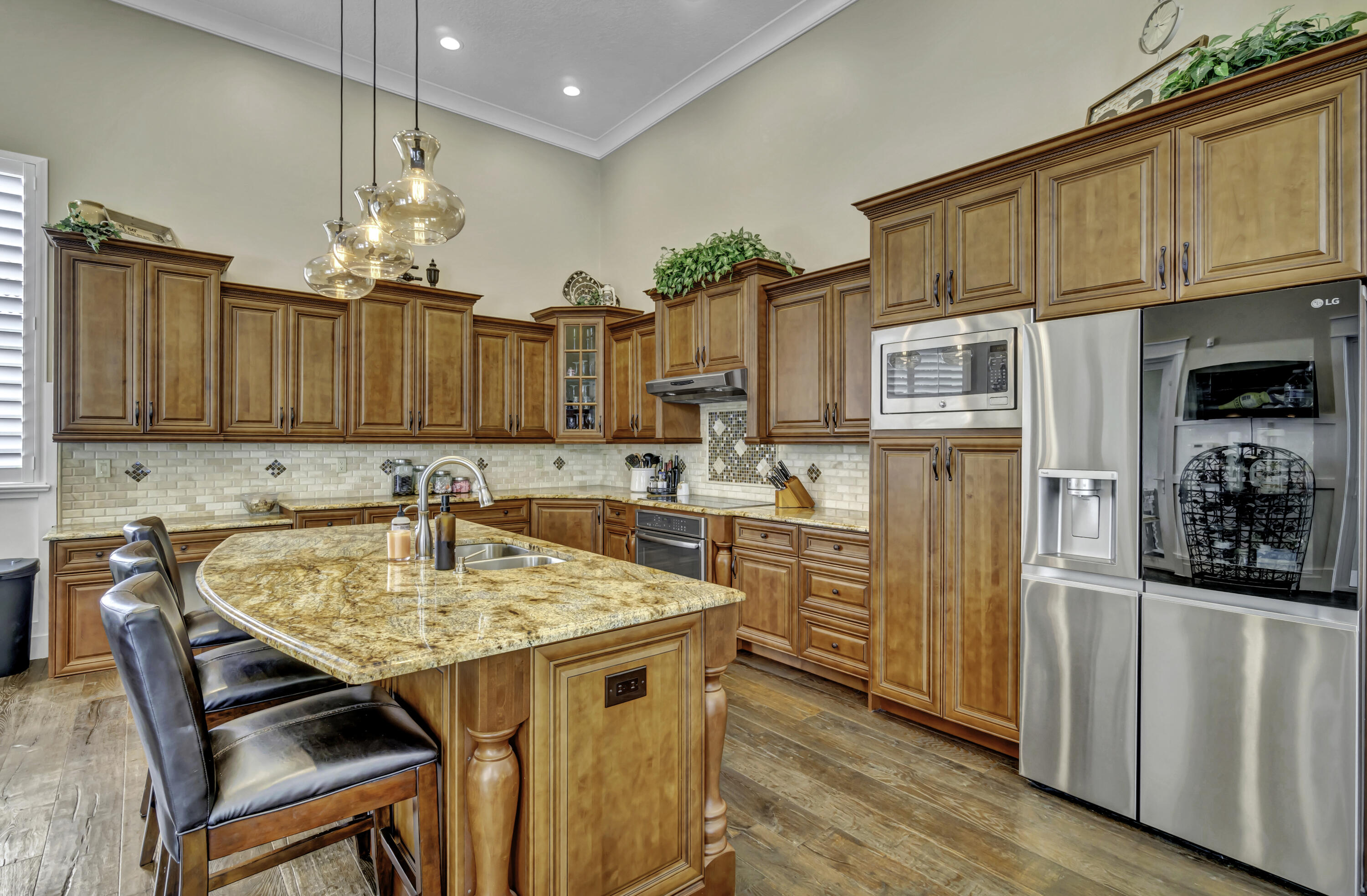 1209 Breakers W Boulevard West Palm Beach, FL 33411 - Photo 27 of 73 a kitchen with stainless steel appliances granite countertop a kitchen island a stove a table and chairs in it