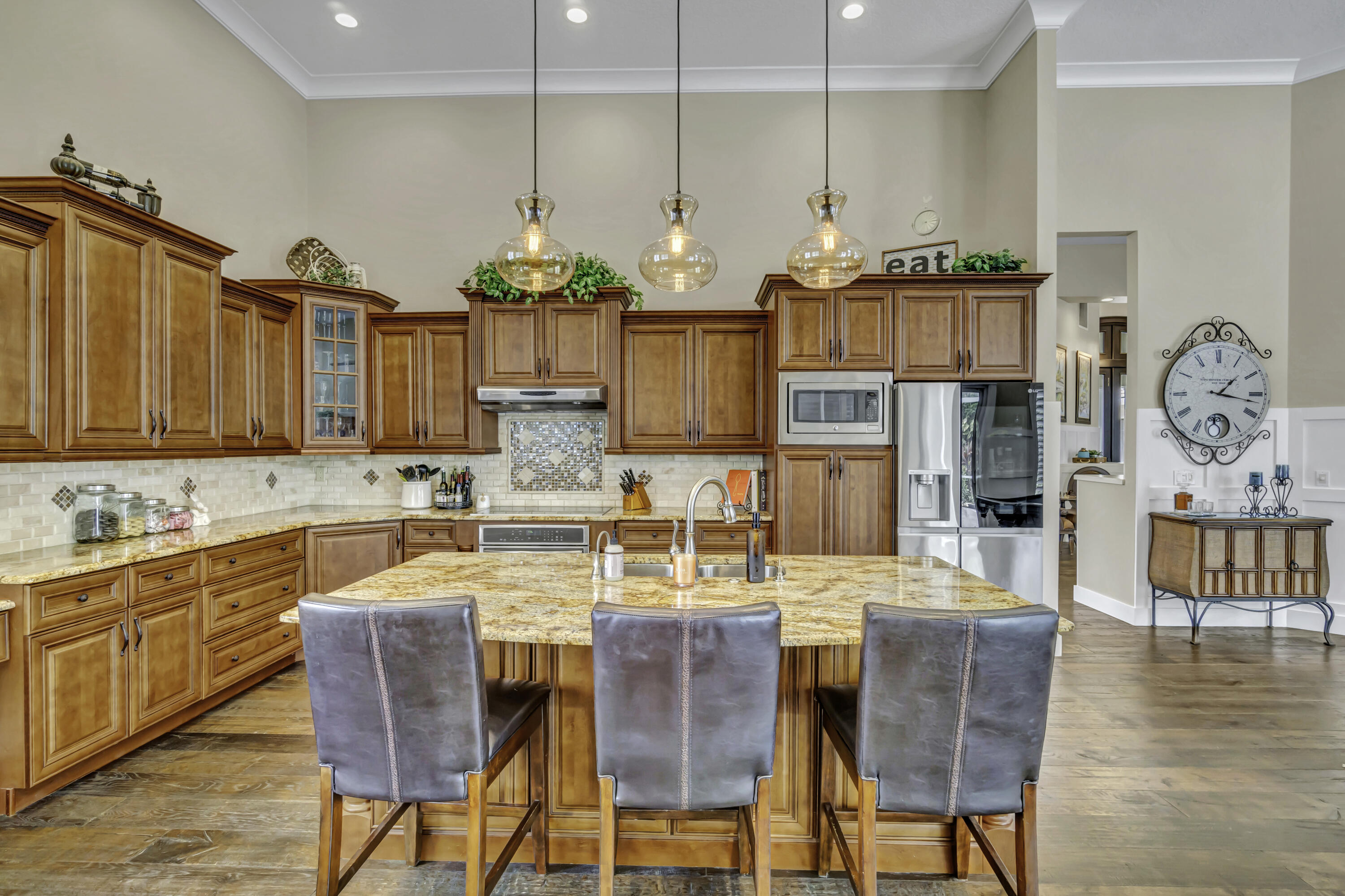 1209 Breakers W Boulevard West Palm Beach, FL 33411 - Photo 28 of 73 a kitchen with stainless steel appliances a dining table chairs and chandelier