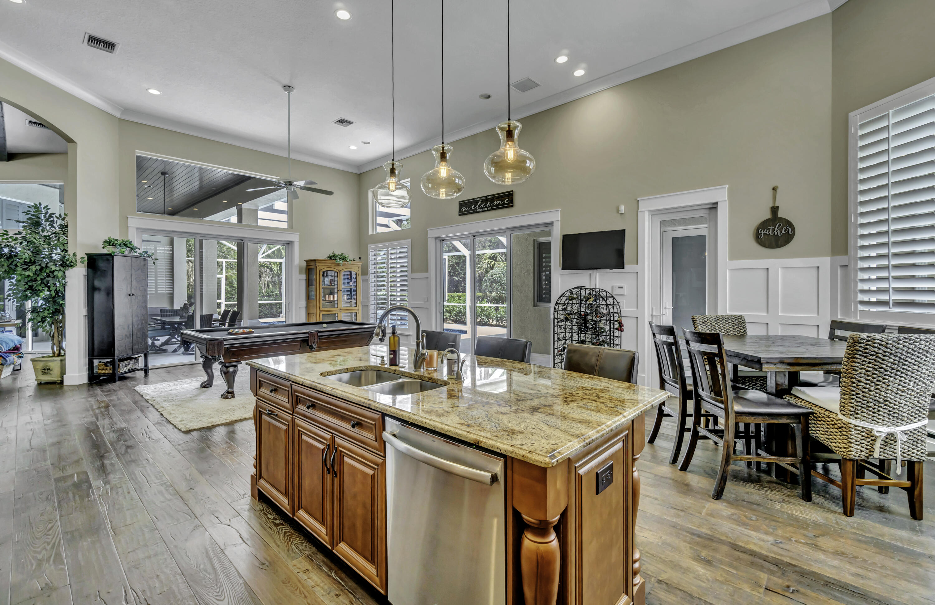 1209 Breakers W Boulevard West Palm Beach, FL 33411 - Photo 32 of 73 a kitchen with stainless steel appliances granite countertop stove a refrigerator a kitchen island a dining table and chairs with wooden floor