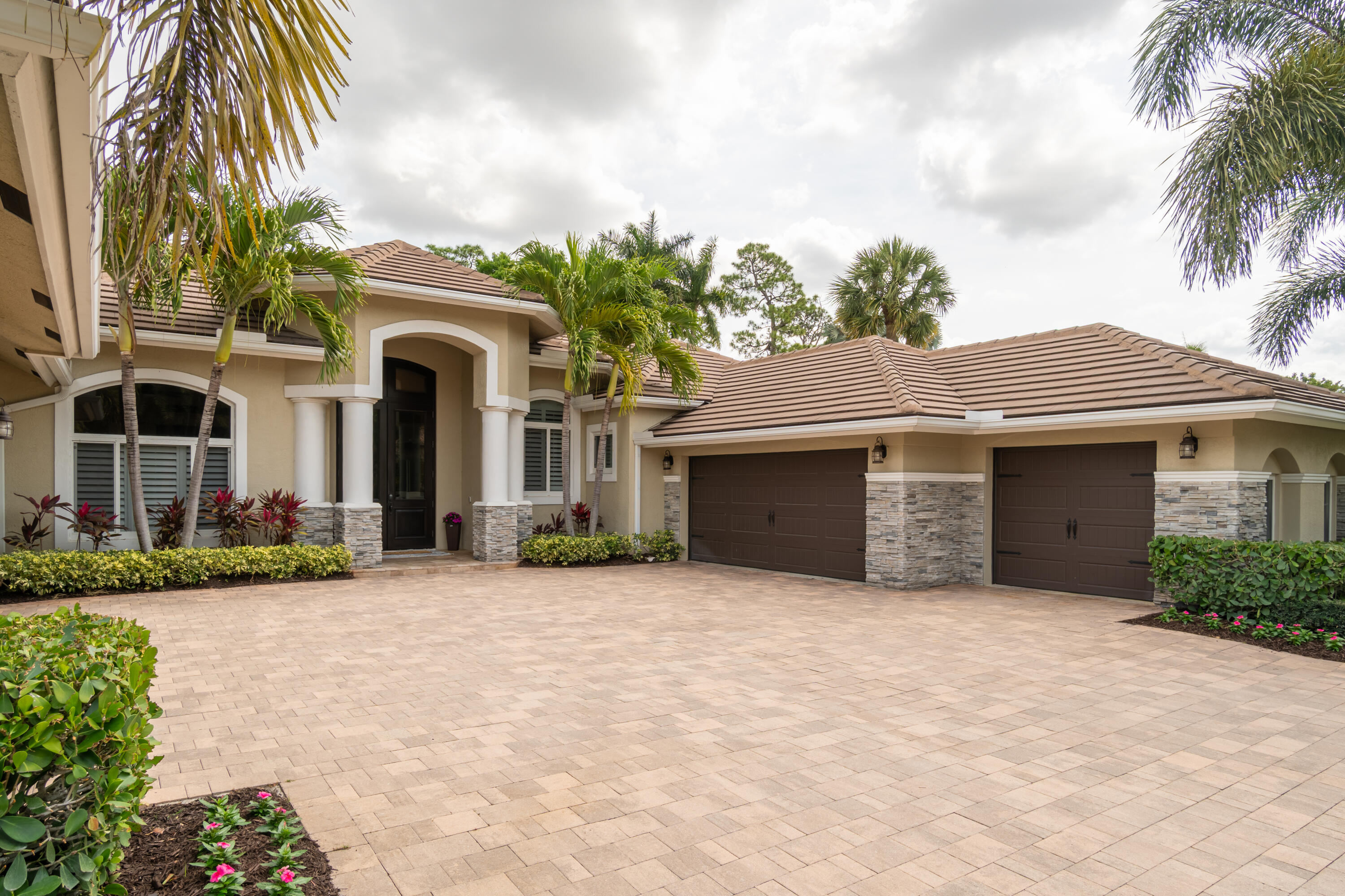1209 Breakers W Boulevard West Palm Beach, FL 33411 - Photo 8 of 73 a front view of a house with a garden and palm trees