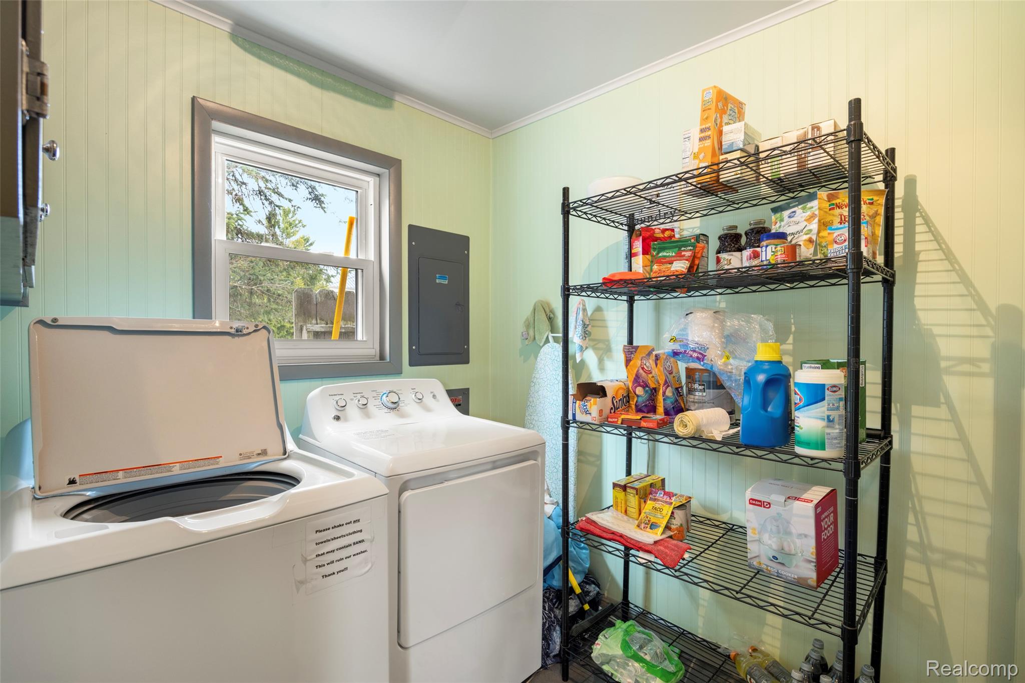 8171 Lakeshore Road Lexington, MI 48450 - Photo 27 of 45 Laundry area featuring electric panel, separate washer and dryer, crown molding, and wooden walls