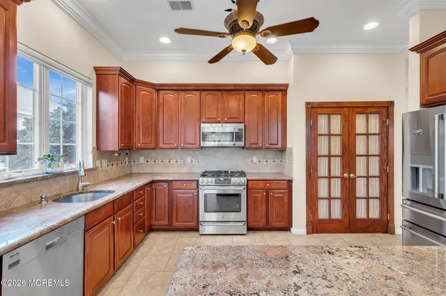 a large kitchen with stainless steel appliances granite countertop a stove a sink and a refrigerator