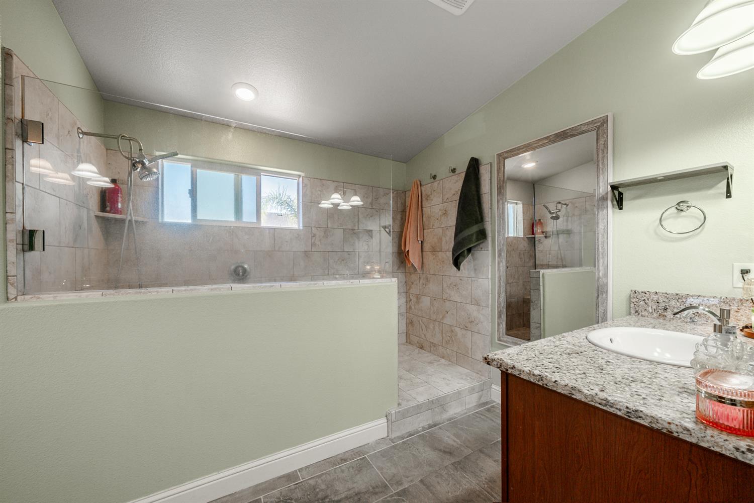 3133 4th Street Sanger, CA 93657 - Photo 21 of 33 a bathroom with a granite countertop sink a large mirror a shower and bathtub