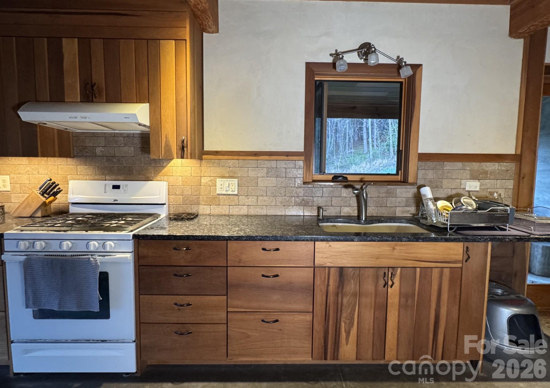 1422 Middle Fork Road Hendersonville, NC 28792 - Photo 14 of 48 a kitchen with granite countertop a sink cabinets and a wooden floor
