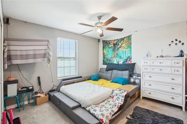 a bedroom with a bed a dresser and a window