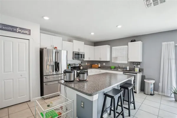 a kitchen with granite countertop a sink and white cabinets