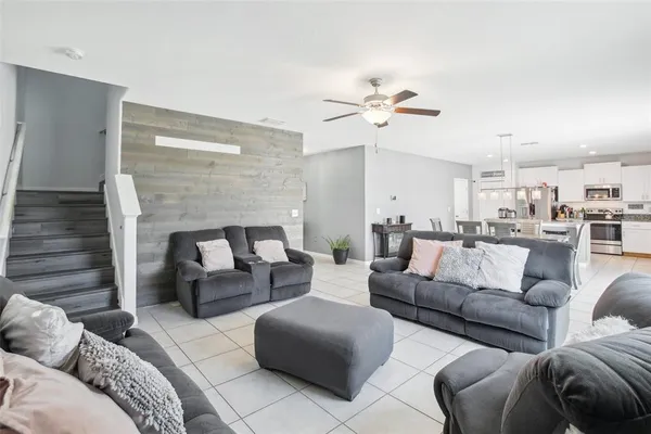 a living room with furniture and view of kitchen