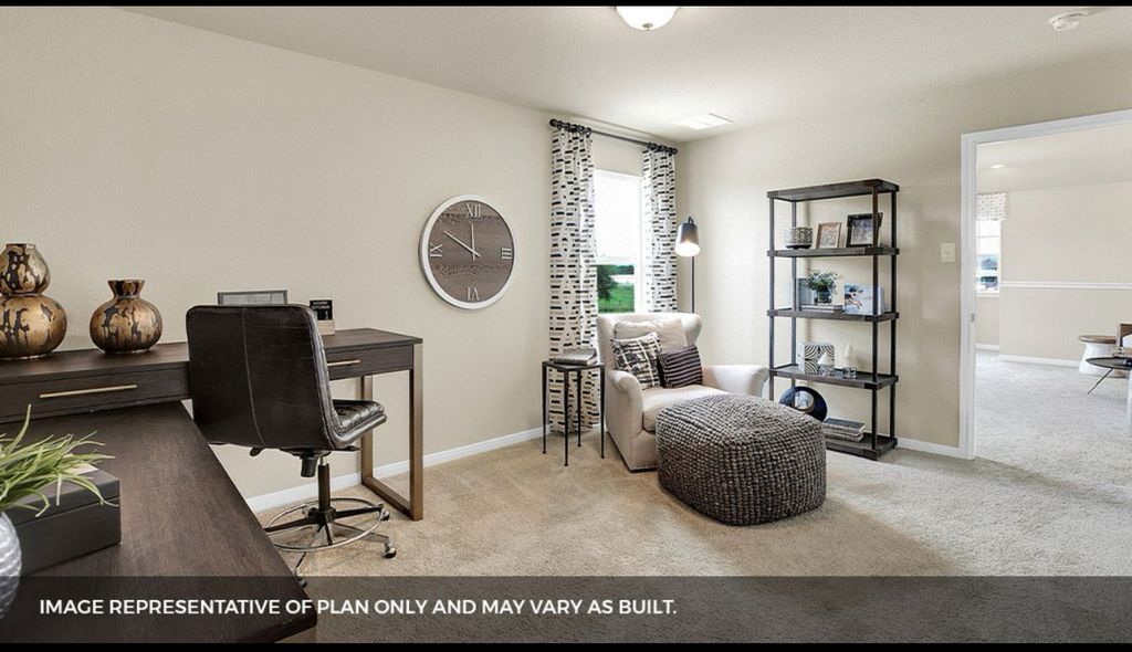 156 Docile Loop San Marcos, TX 78666 - Photo 21 of 40 A well-lit, adaptable room presents a dedicated workspace and a cozy reading nook with plush carpeting.