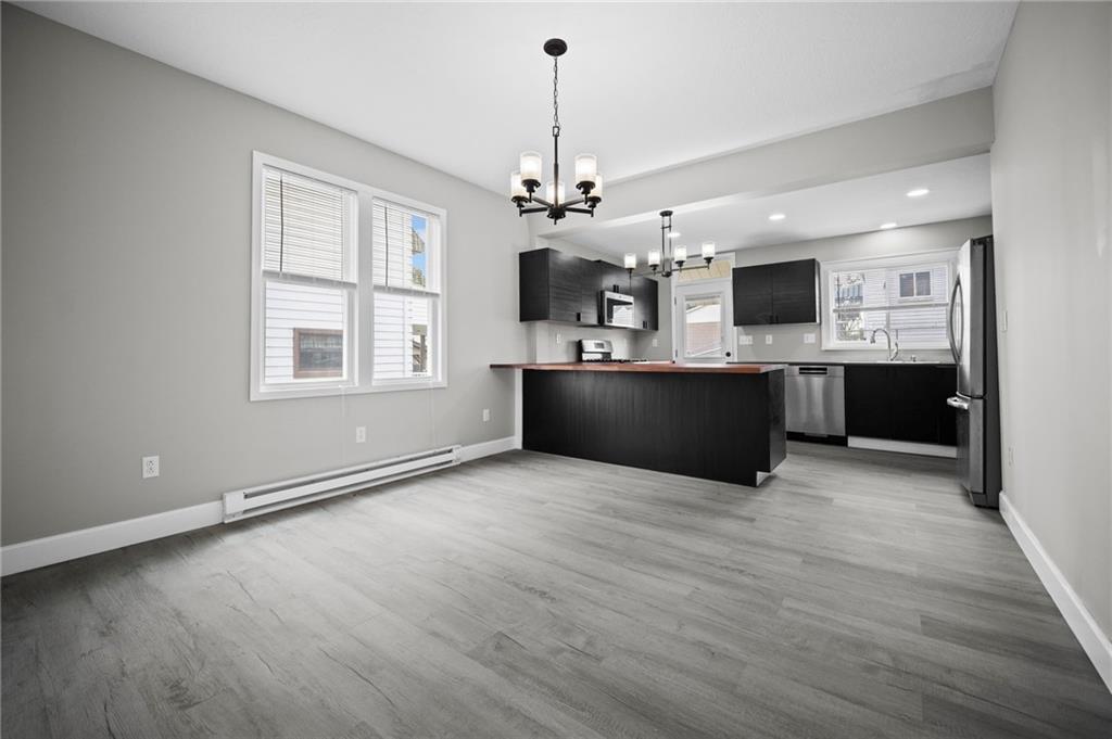 423 2nd Street Donora, PA 15033 - Photo 13 of 47 a view of a kitchen with a stove wooden cabinets and a chandelier