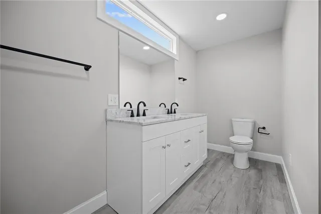 a bathroom with a toilet a sink and mirror