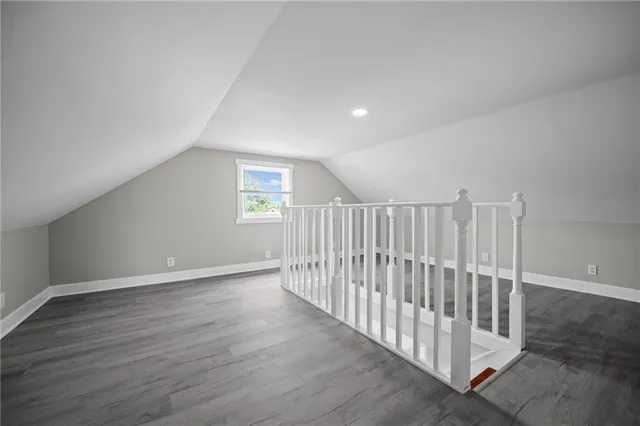 an empty room with wooden floor & windows