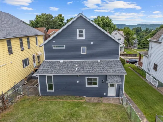 a aerial view of a house next to a yard with potted plants