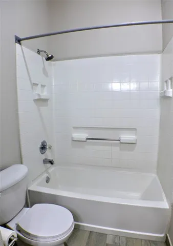 a bathroom with a toilet and a shower