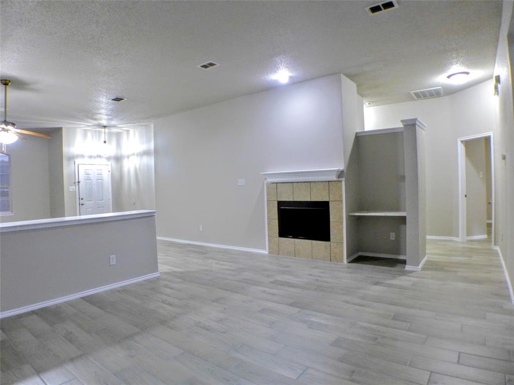7300 Cresswell Drive Arlington, TX 76001 - Photo 4 of 20 a view of an empty room with a fireplace and a window