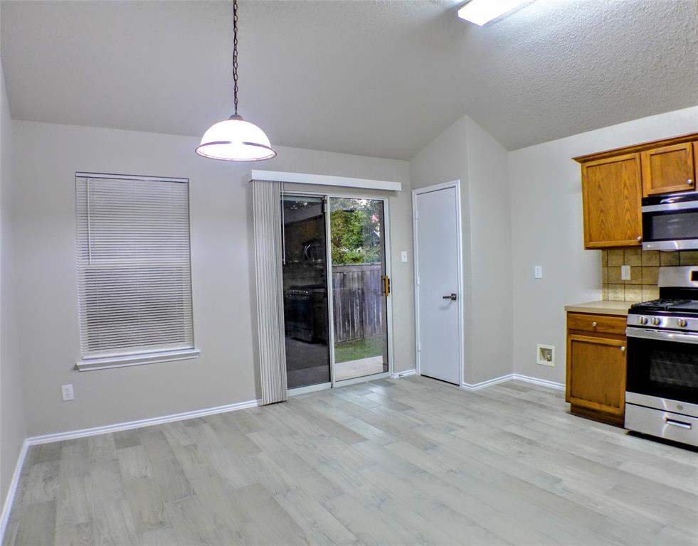 7300 Cresswell Drive Arlington, TX 76001 - Photo 7 of 20 a view of a kitchen with a stove cabinets and a wooden floor