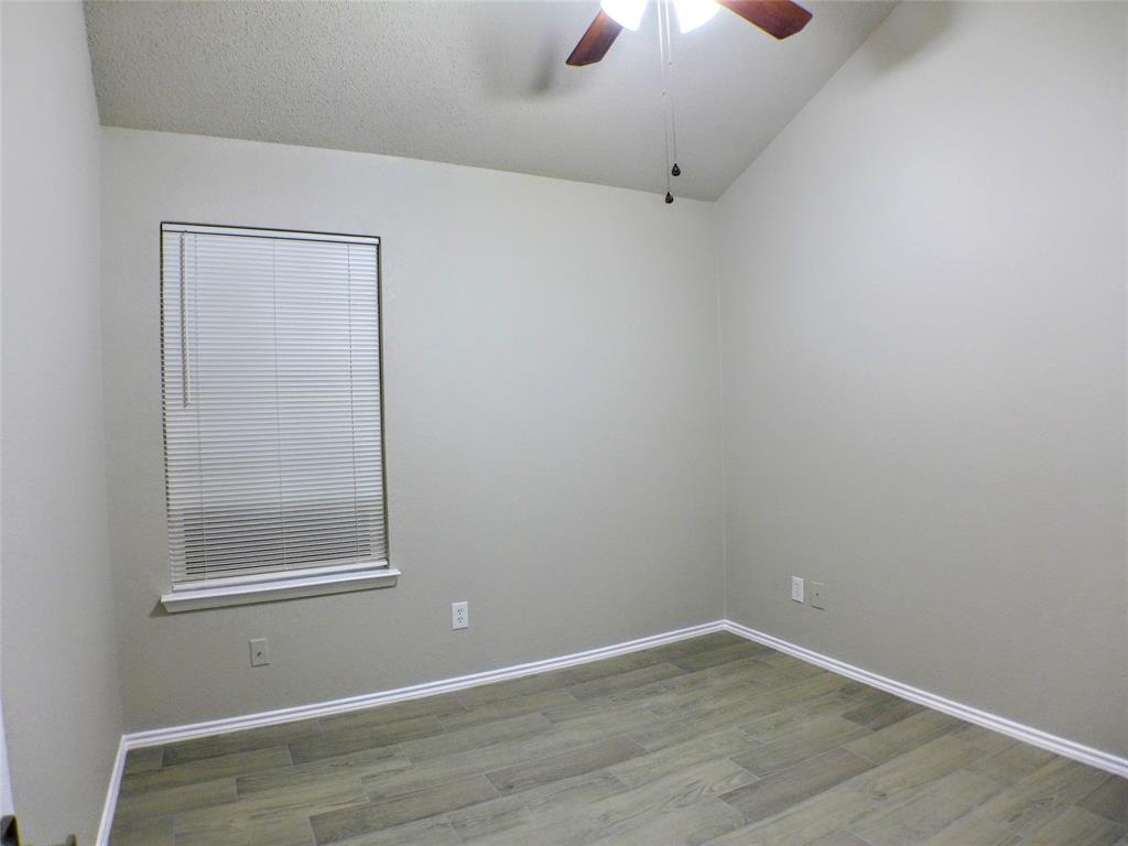 7300 Cresswell Drive Arlington, TX 76001 - Photo 9 of 20 an empty room with a window and chandelier fan