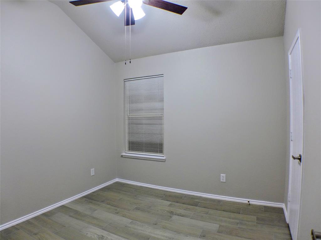 7300 Cresswell Drive Arlington, TX 76001 - Photo 10 of 20 an empty room with wooden floor chandelier fan and windows