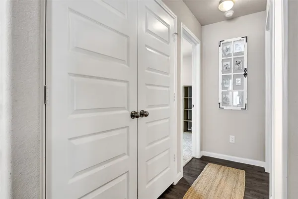 a view of a hallway with wooden floor and closet