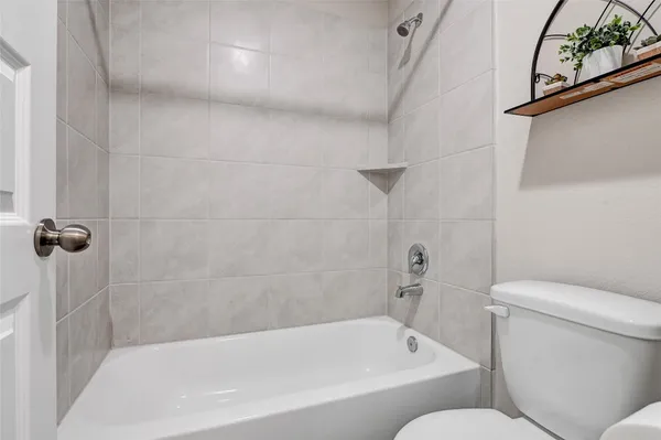a white bath tub sitting next to a toilet