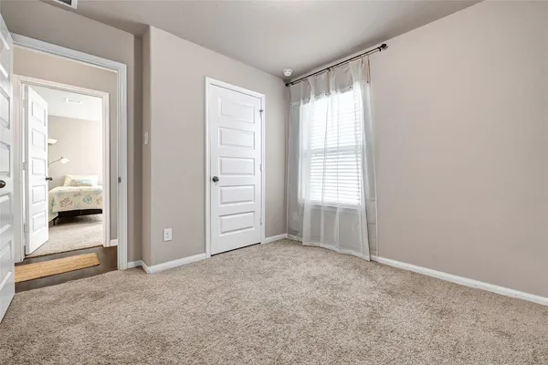an empty room with windows and closet