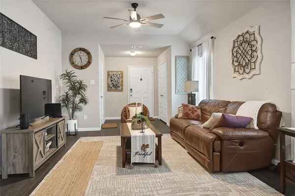 a living room with furniture a flat screen tv and a wall painting