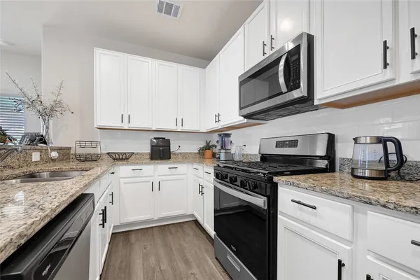 a kitchen with stainless steel appliances granite countertop a sink stove and microwave
