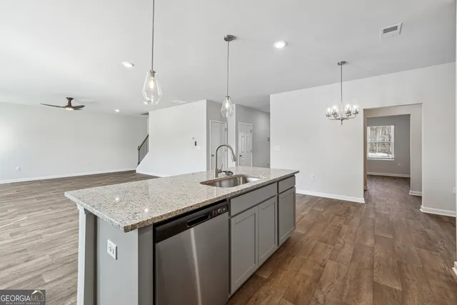 a kitchen with a sink a counter space and wooden floor