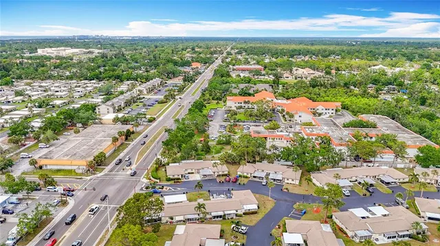 an aerial view of a city with lots of residential buildings ocean and mountain view in back