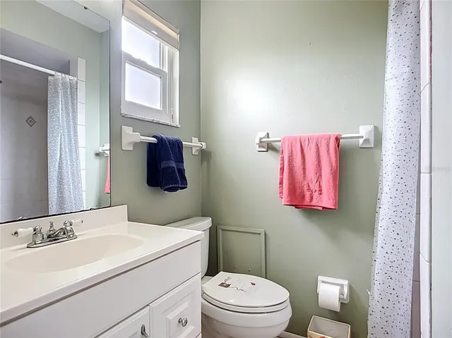 a bathroom with a sink vanity mirror and toilet