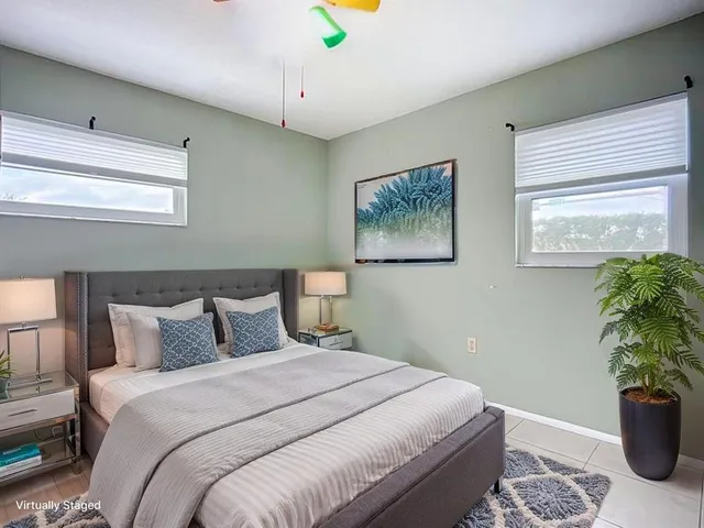 a bedroom with bed and paintings on the wall