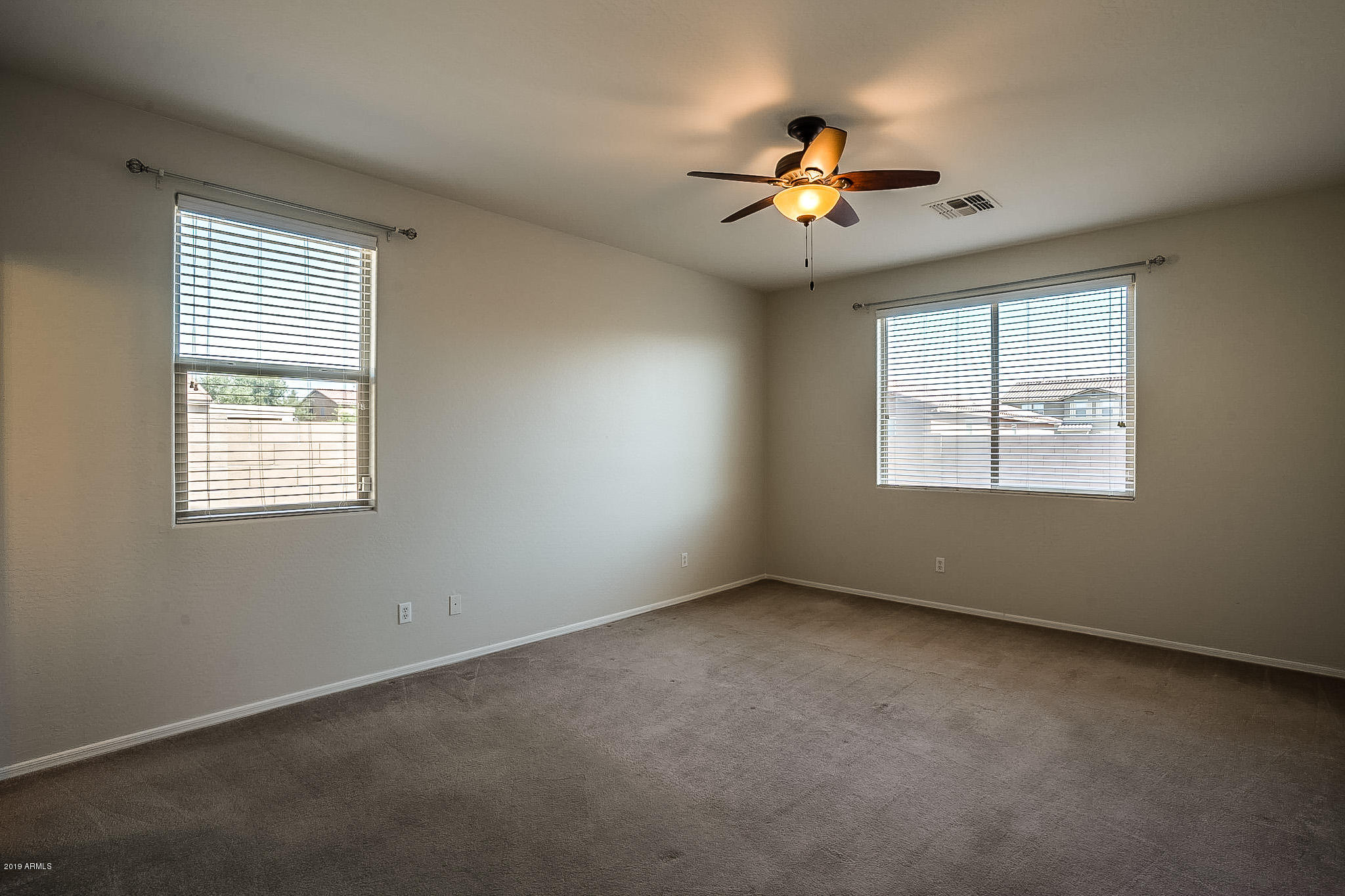 7425 West Darrel Road Laveen, AZ 85339 - Photo 26 of 64 an empty room with windows and chandelier fan