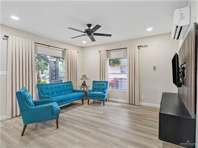 a living room with furniture wooden floor and a large window