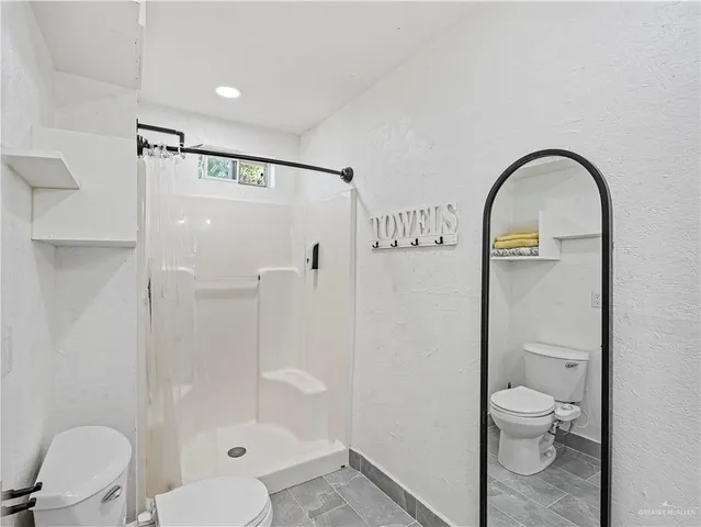 a bathroom with a toilet and a shower