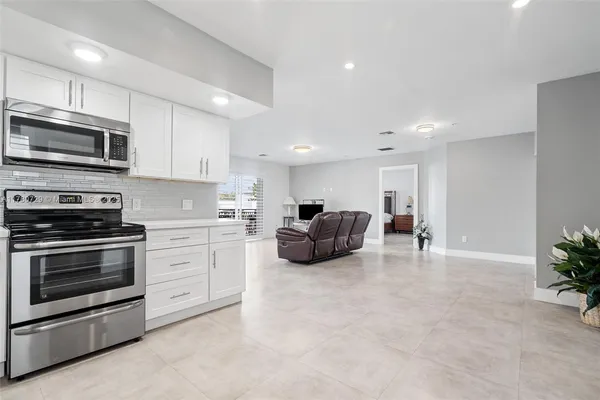 a kitchen with furniture a microwave a stove and cabinets