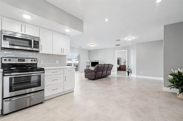 a kitchen with furniture a microwave a stove and cabinets