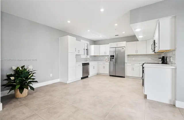a kitchen with white cabinets and stainless steel appliances