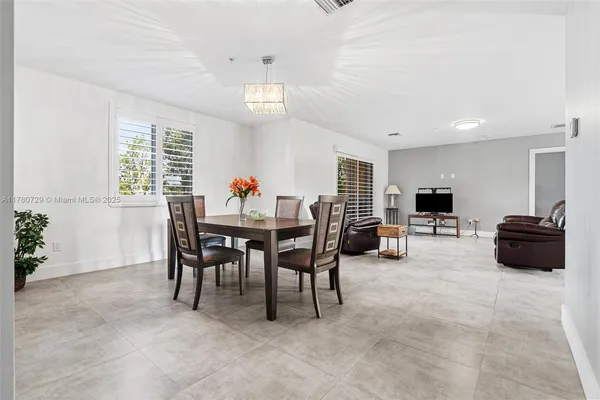 a dining room with furniture a chandelier and window