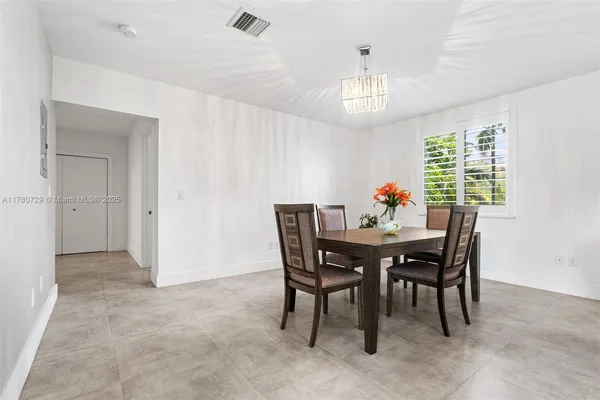 a patio with a table and chairs and potted plants