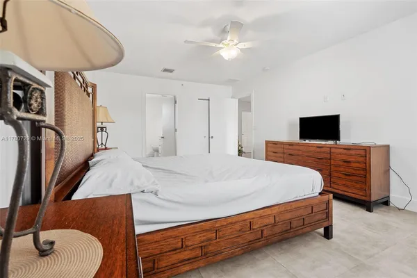 a spacious bedroom with a bed and a chandelier