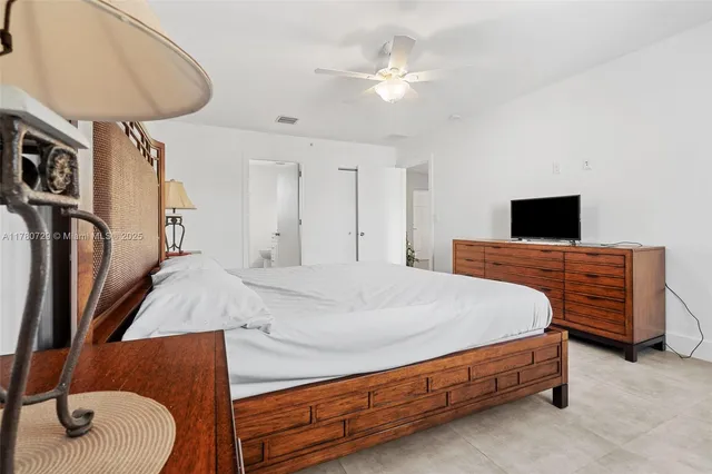 a spacious bedroom with a bed and a chandelier