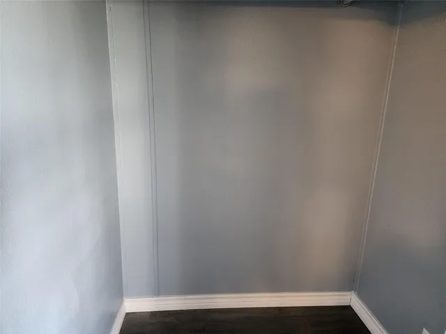 a view of a room with wooden floor and front door