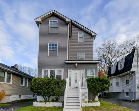a front view of a house with a yard garage and outdoor seating